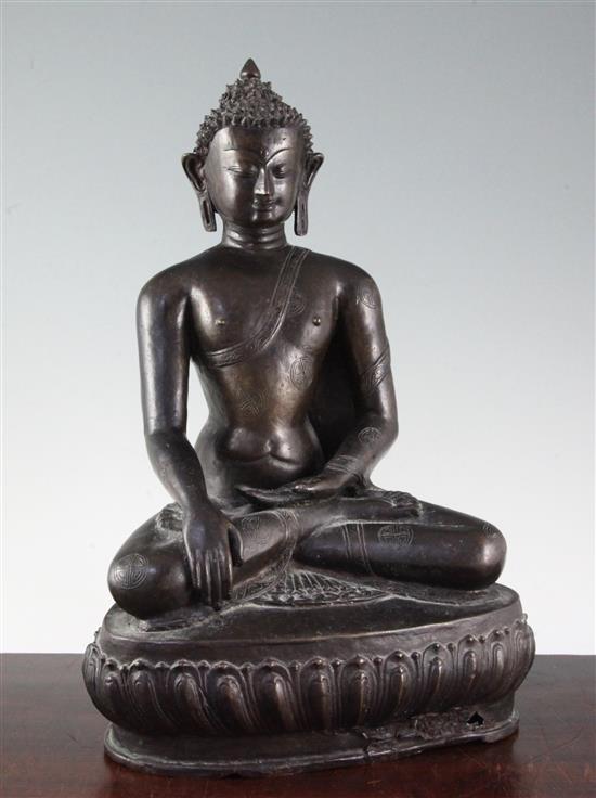 A large Tibetan bronze seated figure of Buddha Shakyamuni, probably 13th century, height 39.5cm, minor old repairs